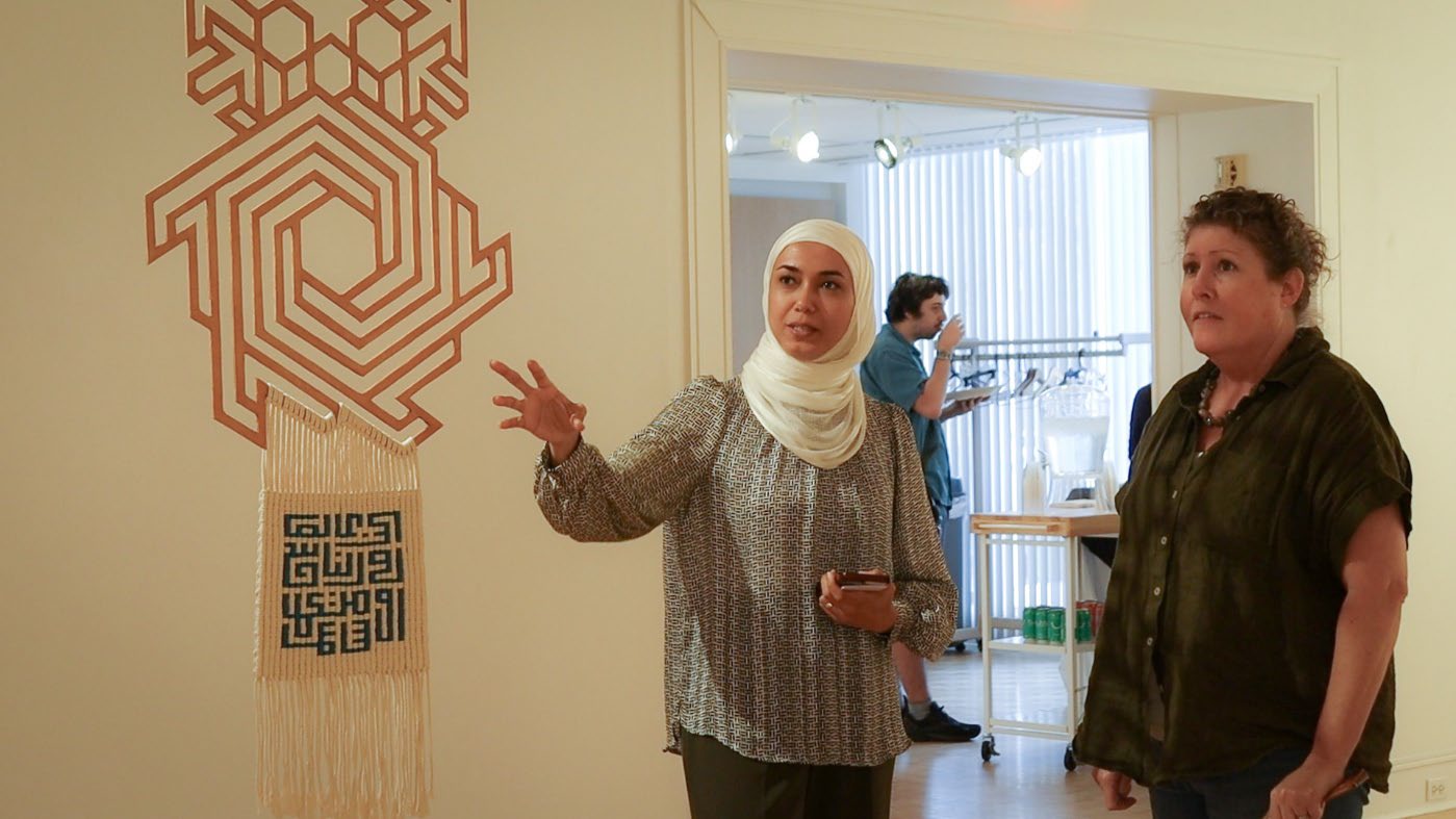 Amal Abdalla explaining the work to a visitor