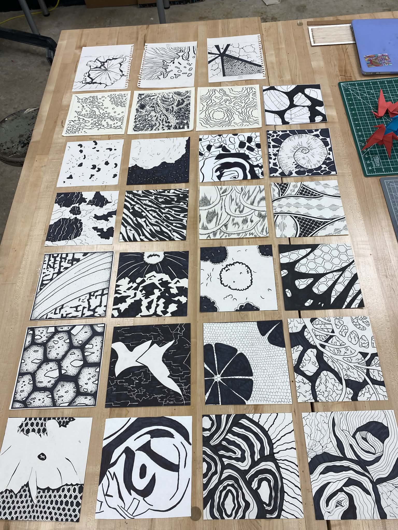 Student work laid out for critique — full table